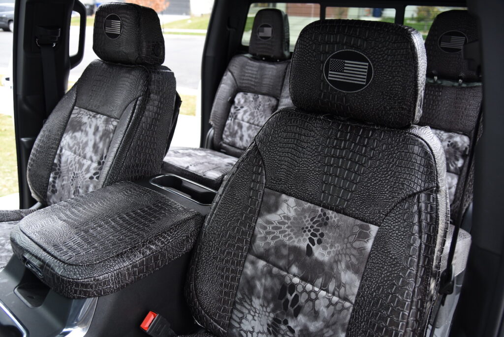 2025 Chevy Silverado 2500 front Kryptek Raid seat covers with Ebony Croc trim and center console cover