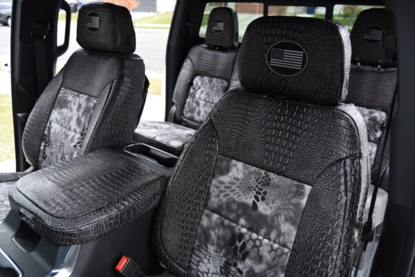 2025 Chevy Silverado 2500 front Kryptek Raid seat covers with Ebony Croc trim and center console cover