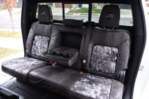 2025 Chevy Silverado 2500 rear Kryptek Raid seat covers with Ebony Croc trim and fold-down armrest