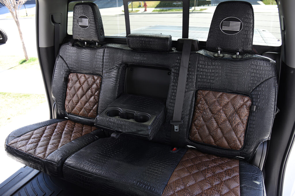 2024 GMC Sierra 3500 rear armrest with cup holders in Java Croc Diamond Stitch and Midnight Croc seat covers