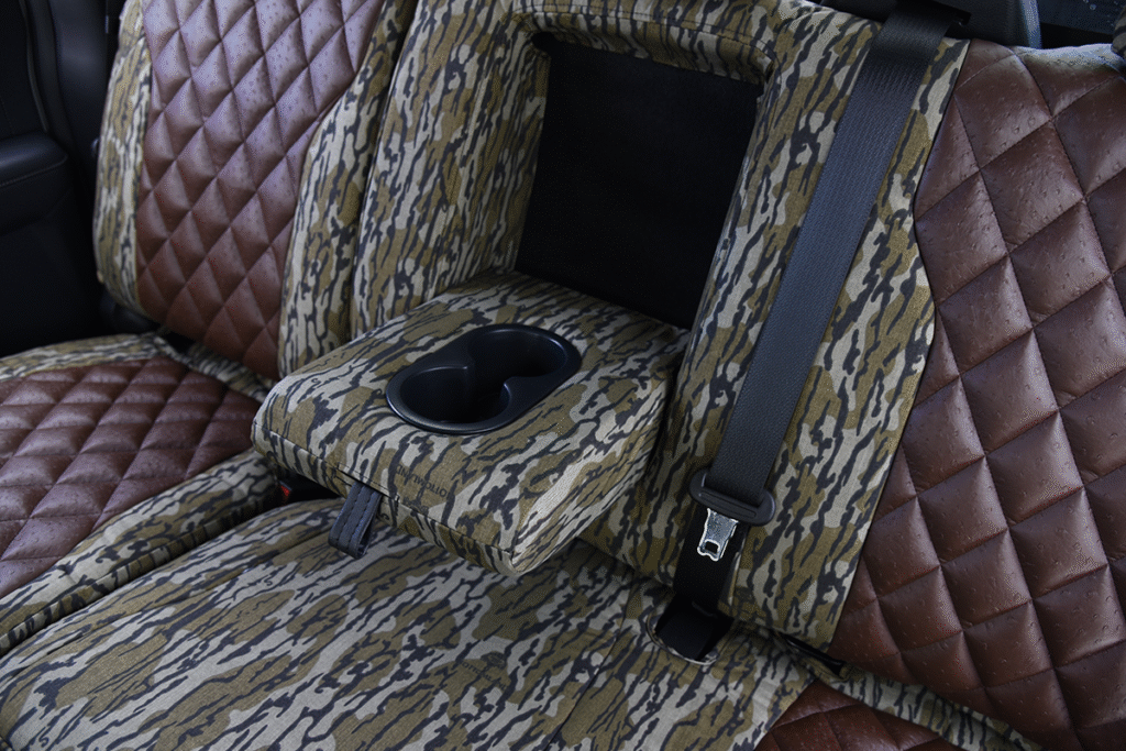 Rear cupholder view of 2026 Ford F-350 seat covers in Brown Ostrich Diamond Stitch leatherette and Mossy Oak Bottomland camouflage