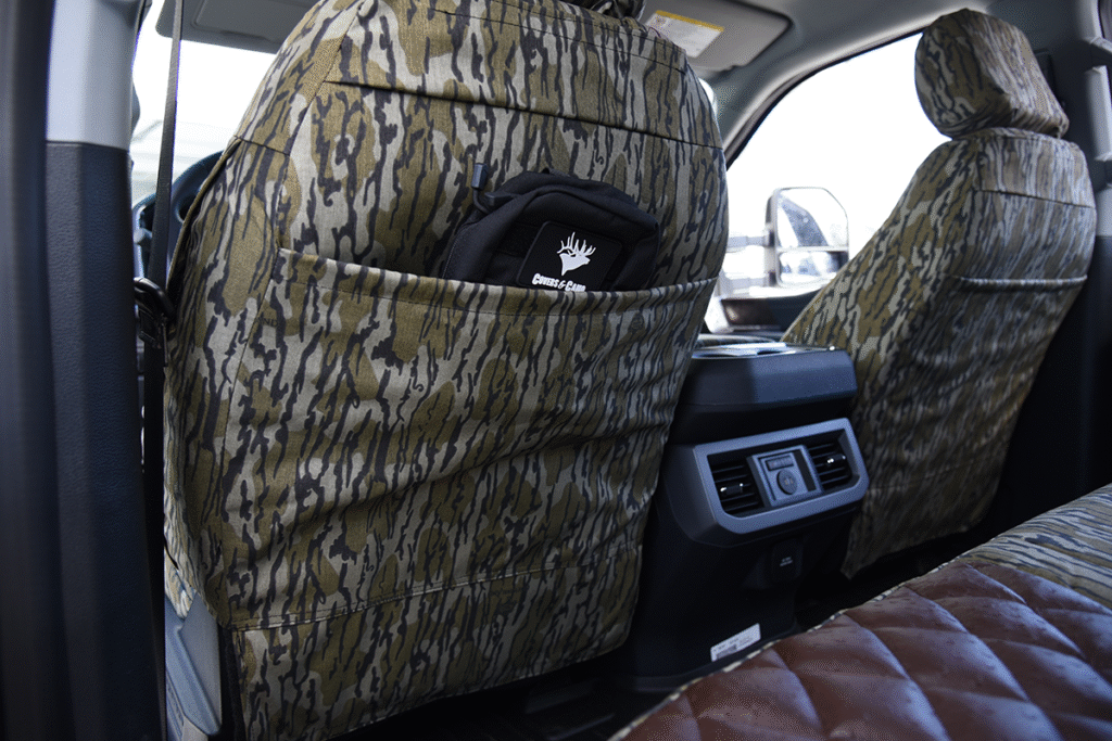 Rear pocket view of 2026 Ford F-350 seat covers in Brown Ostrich Diamond Stitch leatherette and Mossy Oak Bottomland camouflage